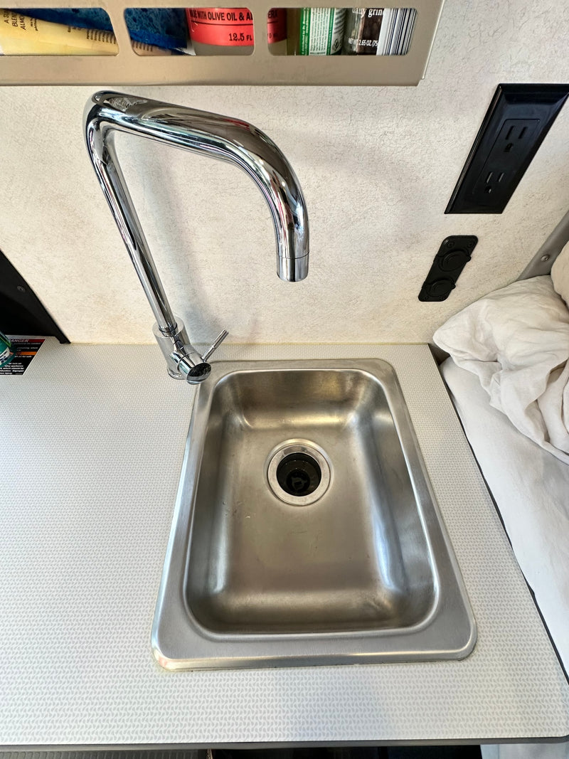  parked on a sunny street with a blue sky.|Front view of a white Winnebago camper van — photo 15