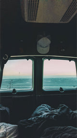 Enjoy breathtaking ocean views from a comfortable bed inside an rv rental, perfect for road trips.