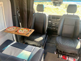 RV rental: Cozy camper van interior with swivel front seats, a dining table, and a clear view out the windshield.