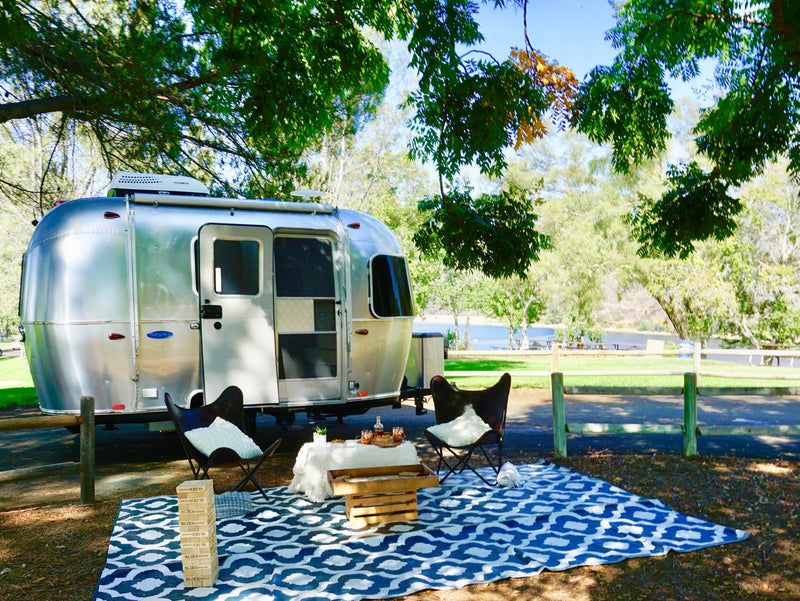 Scenic lakeside RV rental: A shiny Airstream with a welcoming outdoor glamping setup, perfect for relaxation. — photo 6