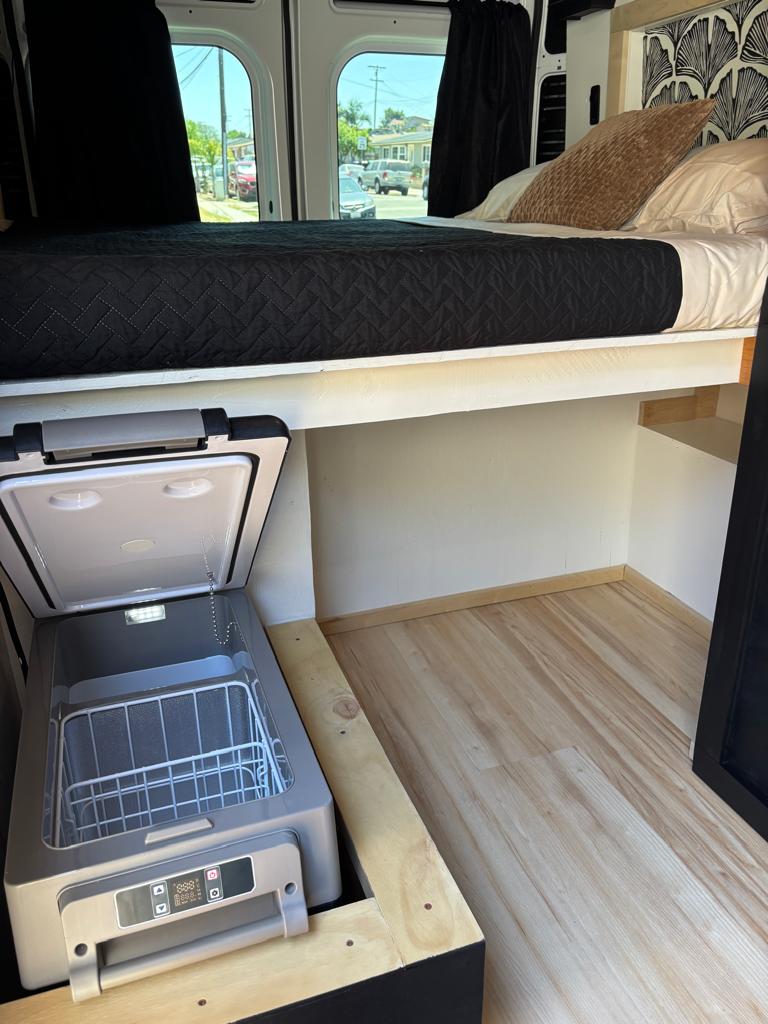  and backyard view.|RV rental: Compact camper van interior with a black kitchenette — photo 8