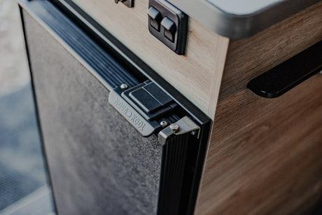 Nova Kool fridge door latch and switches integrated into a light wood cabinet, perfect for your RV rental.