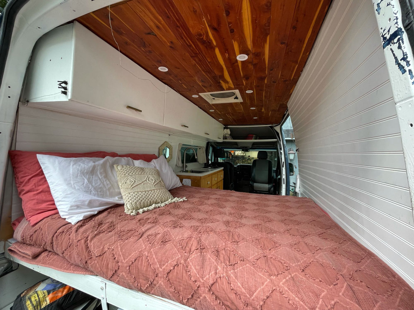 Cozy camper van interior: a comfortable bed, wooden ceiling, and kitchenette. Perfect for an rv rental adventure. — photo 6