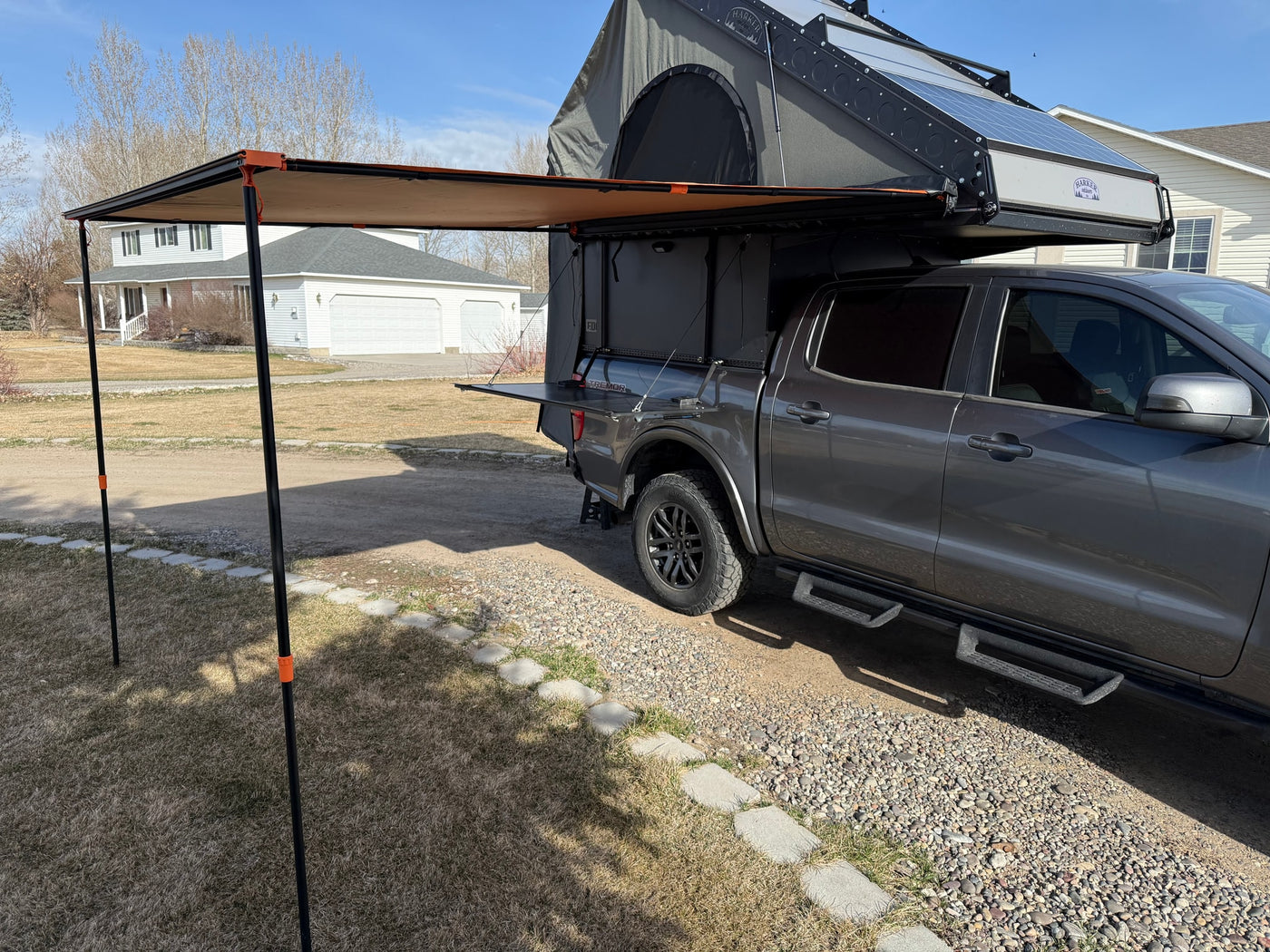 Explore the outdoors with this versatile RV rental: a truck equipped with an overlanding camper, awning, and solar panels. — photo 7
