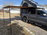 Explore the outdoors with this versatile RV rental: a truck equipped with an overlanding camper, awning, and solar panels.