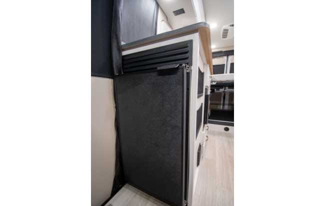 Enjoy convenient amenities in this RV rental! Features a compact refrigerator and sleek cabinetry for comfortable travel.