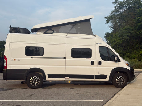  ideal for adventurous road trips.|White Winnebago Solis camper van with pop-top roof