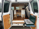 This RV rental offers a glimpse inside a custom camper van with a cozy kitchen and outdoor cooking setup.
