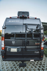 Rear view of a dark gray Thor Sequence RV rental, a Ram ProMaster camper van, with a bike rack.