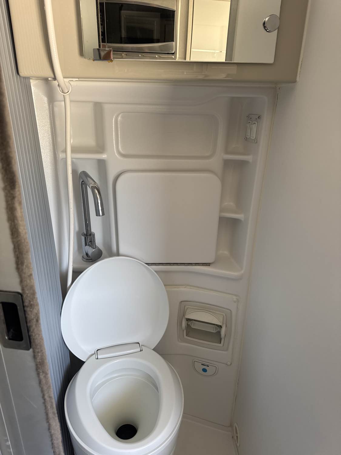  and a wall-mounted table.|Inside an RV rental: Enjoy the view through the roof skylight. Features include overhead cabinets & a TV — photo 1