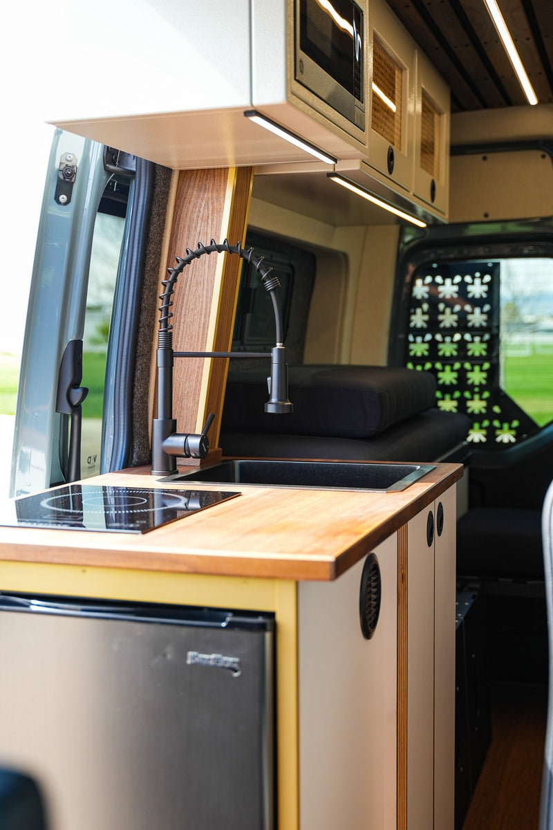  and bed area.|This RV rental features a compact kitchen with induction cooktop — photo 3