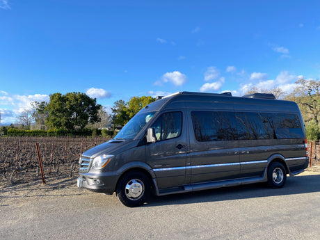 Grey Roadtrek Mercedes-Benz Sprinter RV rental parked by a winter vineyard. Explore