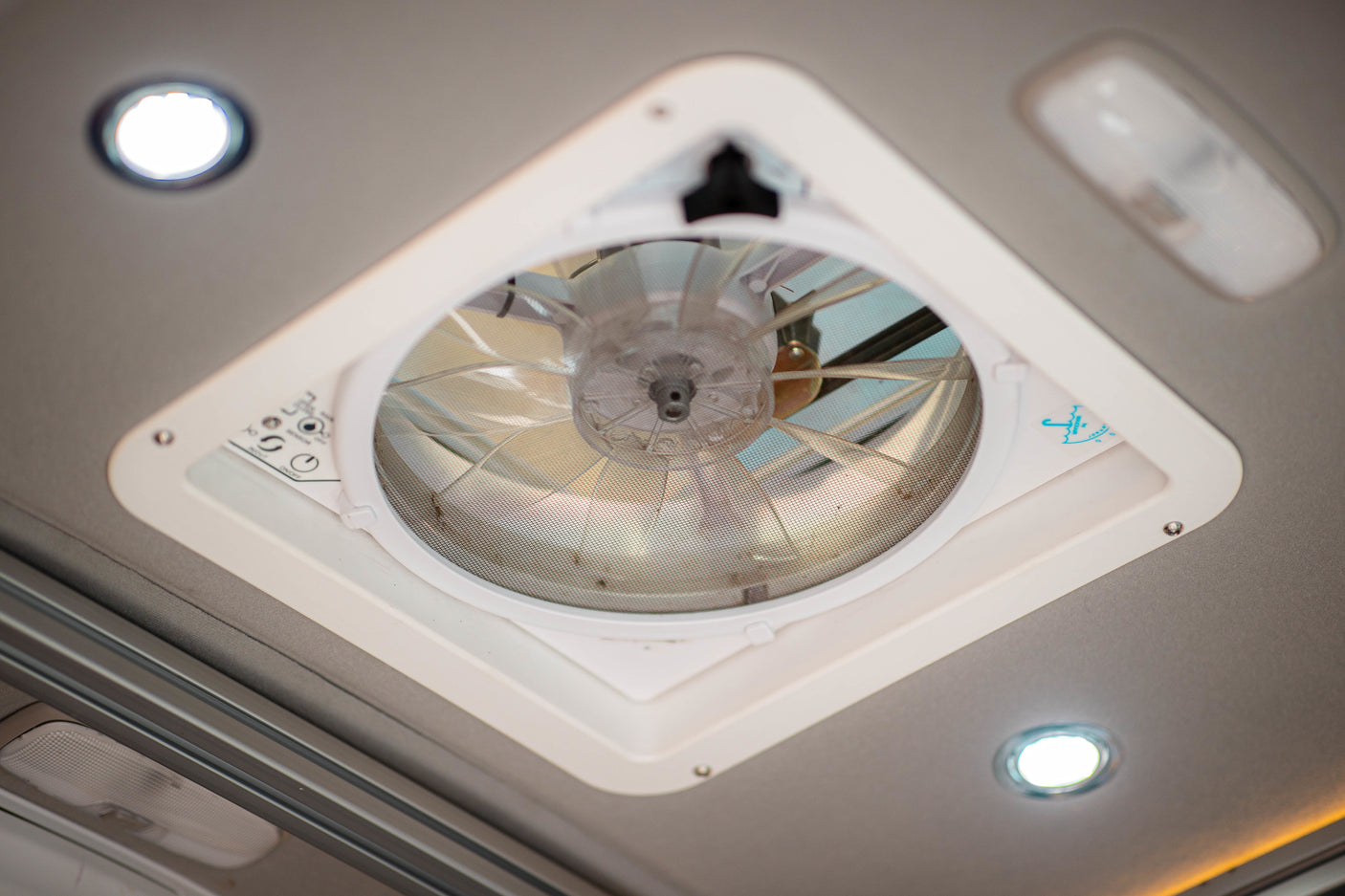 RV rental interior: Roof fan/vent with a mesh screen and surrounding ceiling lights.