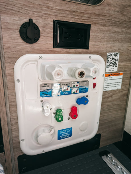 This RV water control panel features multiple valves and modes for connections like city water, dry camping, and winterizing, ideal for RV rental.