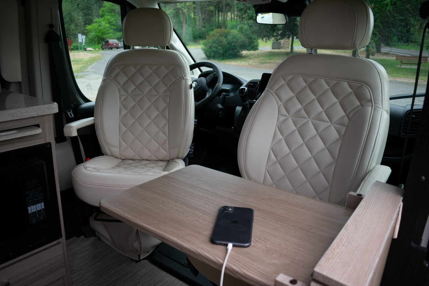  featuring comfortable bench seating and overhead storage.|Black Ram ProMaster rv rental van by a serene lake — photo 15