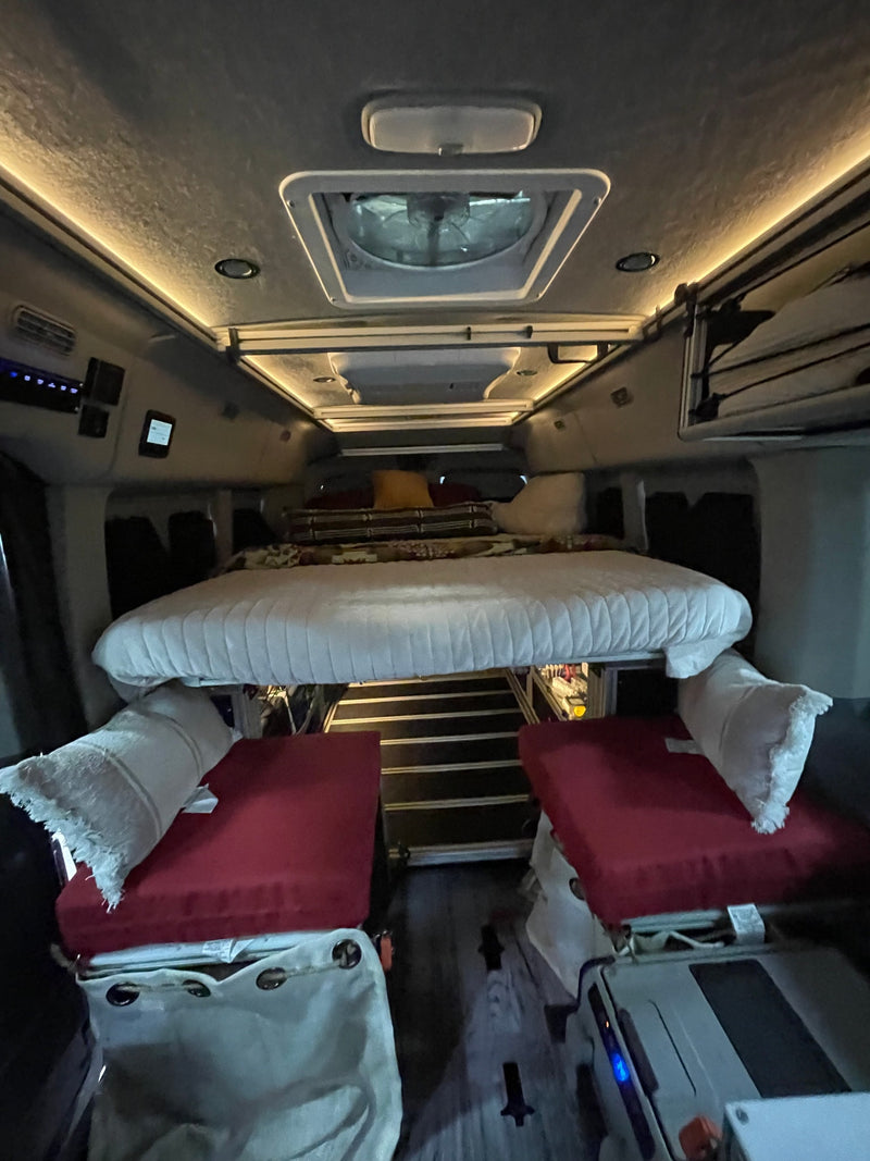 This RV rental interior features comfy upper and lower bunk beds, strip lighting, and a roof vent, ideal for road trip comfort. — photo 15