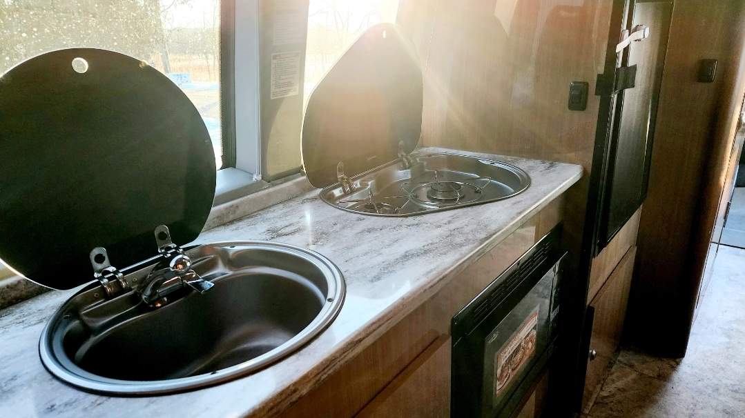  perfect for road trips. Features comfortable seating and a table.|Bright RV rental interior featuring a dinette — photo 3