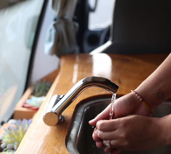 Staying hygienic in an RV rental: Hands washing at a compact sink, perfect for van life adventures. — photo 6