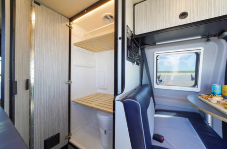This RV rental features a compact interior with a multi-functional bathroom/shower and a cozy seating area.