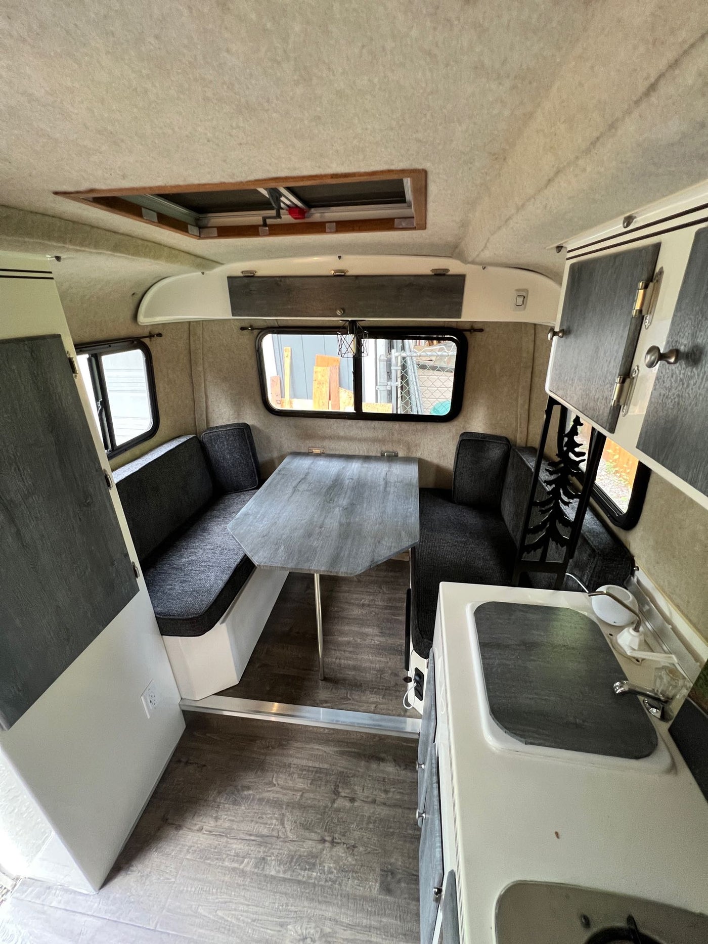 Inside this RV rental: a modern kitchen, comfy dining booth, and bright interior, ready for your road trip comfort. — photo 8