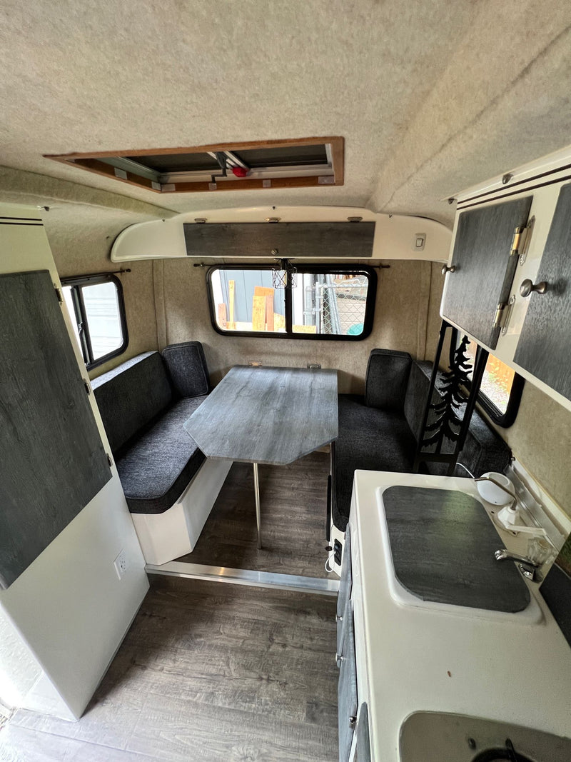 Inside this RV rental: a modern kitchen, comfy dining booth, and bright interior, ready for your road trip comfort. — photo 8
