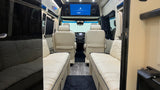 Step inside this modern rv rental, featuring luxurious cream seating, wood-look floor, and an overhead entertainment screen.