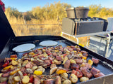 Cooking up a delicious camp breakfast on a griddle with sausage, potatoes, and pancakes. Perfect for your RV rental journey!