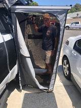 Smiling man in RV rental shower tent, perfect for private outdoor camping.