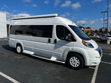 This white camper van makes an ideal RV rental. Ready for travel, it's parked under a blue sky.