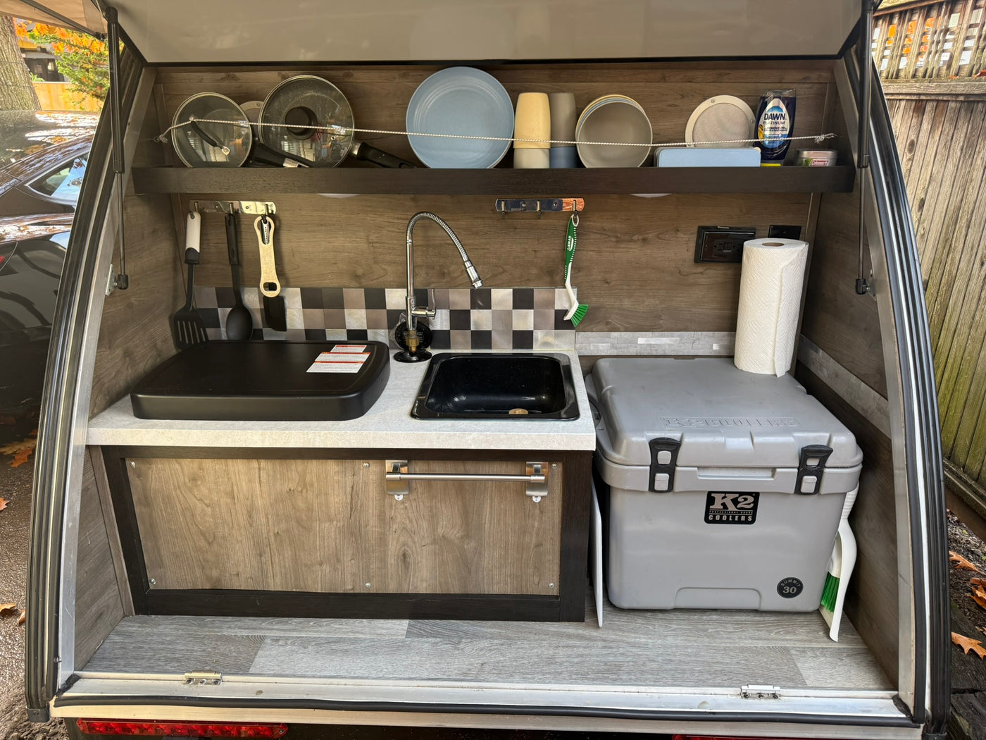 Compact RV rental outdoor kitchen: sink, griddle, cooler, dishes, and essentials. Perfect for camping adventures. — photo 3