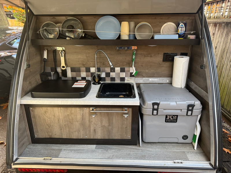 Compact RV rental outdoor kitchen: sink, griddle, cooler, dishes, and essentials. Perfect for camping adventures. — photo 3