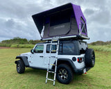 This white Jeep Wrangler, with a purple Elevated Tents roof top tent and ladder, is ideal for an overland RV rental camping trip.