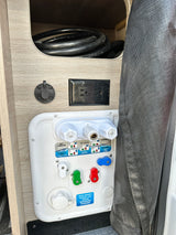 RV rental utility panel: Nautilus P3 water controls, AC outlet, and Zamp solar port for seamless camping.