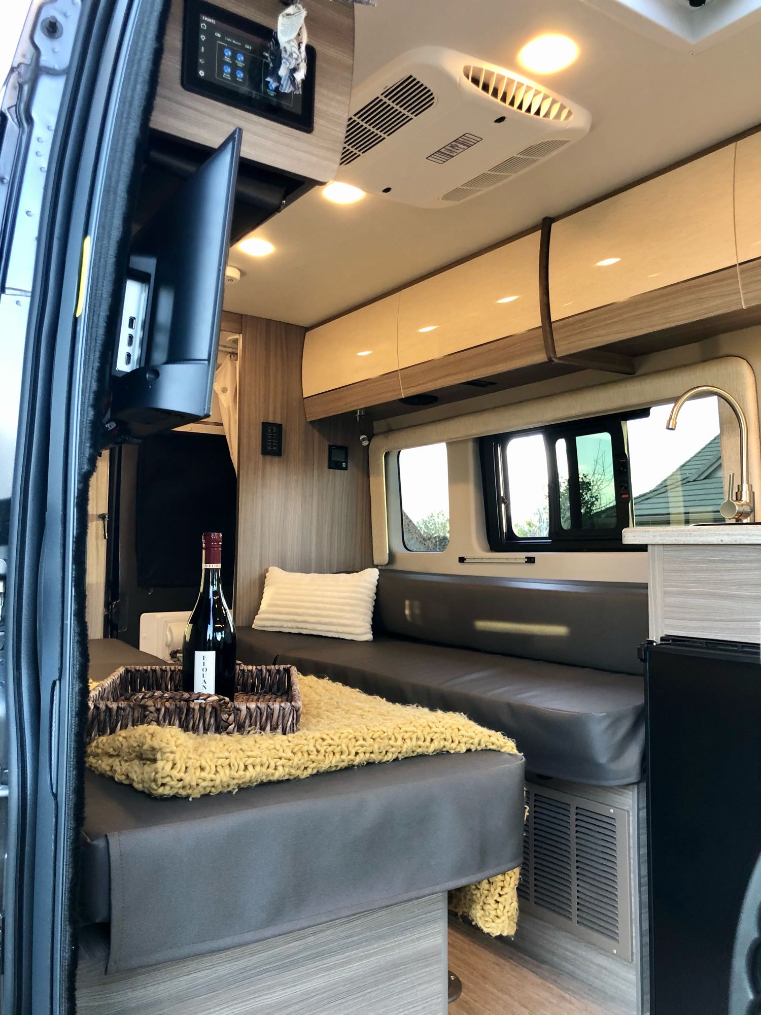 Step inside this cozy RV rental's inviting living space, featuring a dining area, kitchen, and comfortable seating.