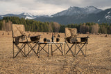 Enjoy a peaceful RV rental getaway. Camping chairs & table set up in a scenic dry landscape with mountains.