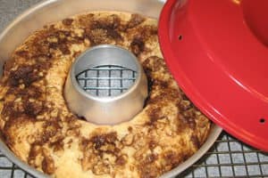 Freshly baked, swirled Bundt cake in its pan on a rack, red lid nearby. Ideal for an RV rental dessert!