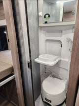 RV rental wet room: a compact bathroom with a toilet, foldable sink, and shower, designed for efficiency.