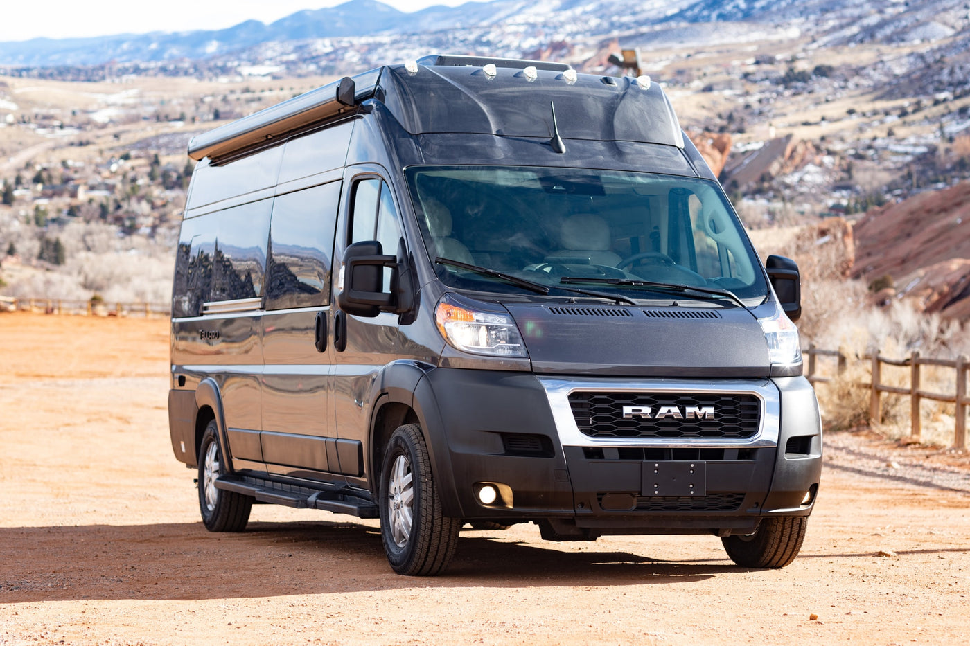  with mountains and red rock formations visible.|Dark gray Thor Motor Coach Tellaro camper van with extended awning & bike rack — photo 10