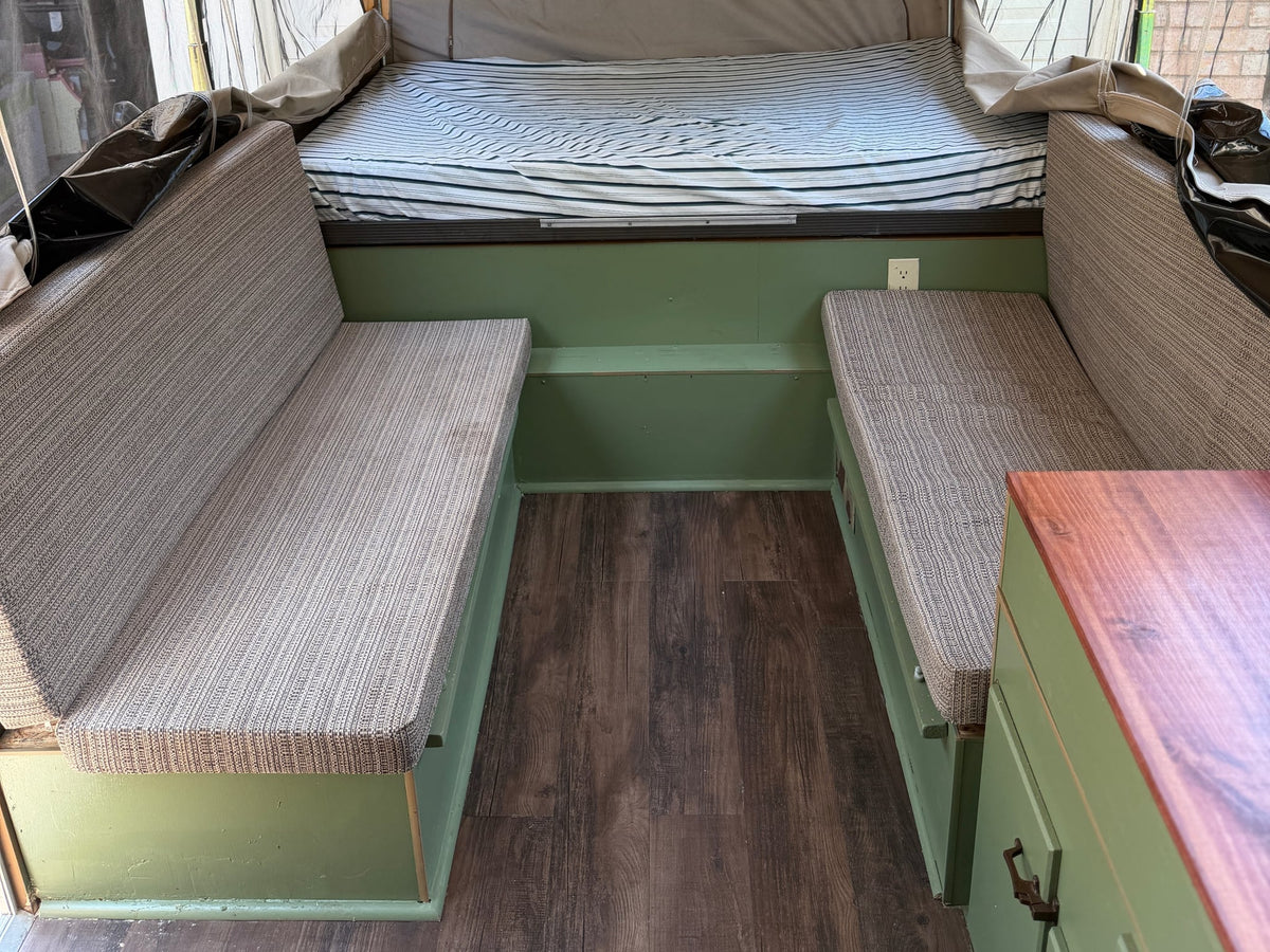  and gear at a sunny campsite.|Cozy rv rental pop-up camper interior with a comfy bed — photo 5