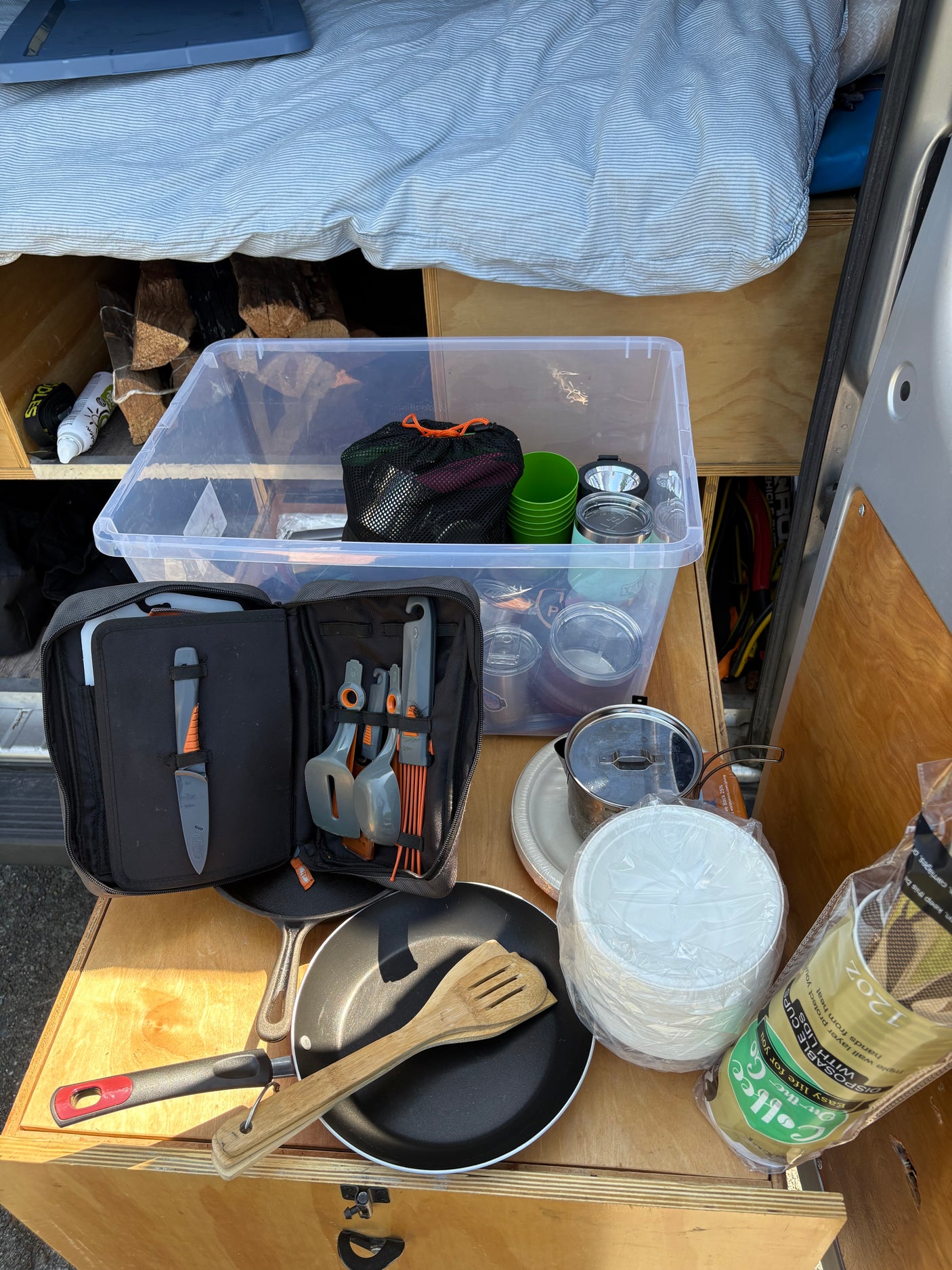 RV rental: Compact van kitchen & camping gear. Pans, utensils, storage, & bedding organized for adventure.