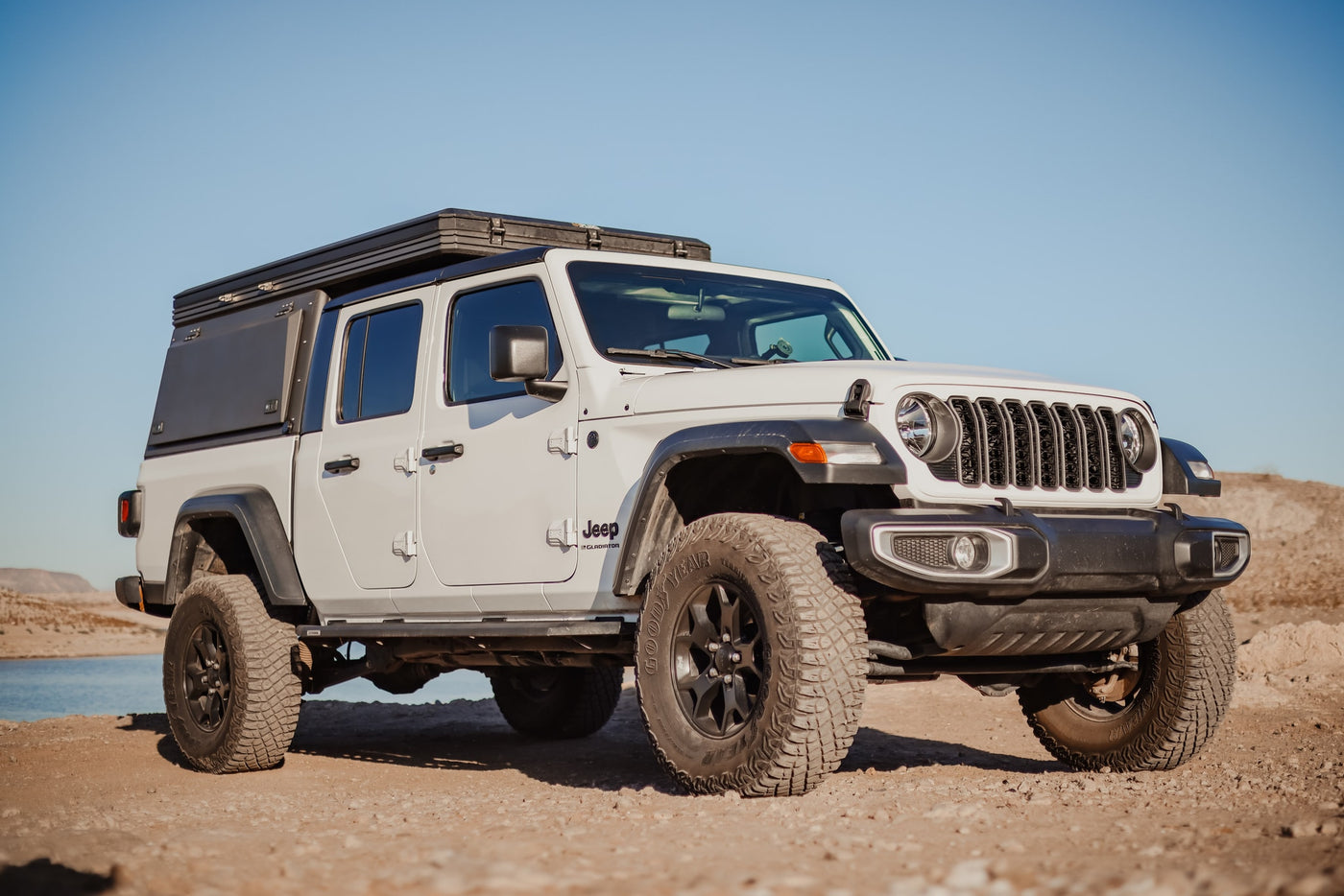 White Jeep Gladiator overland truck with camper on dirt by lake. Ideal for RV rental adventures! — photo 5