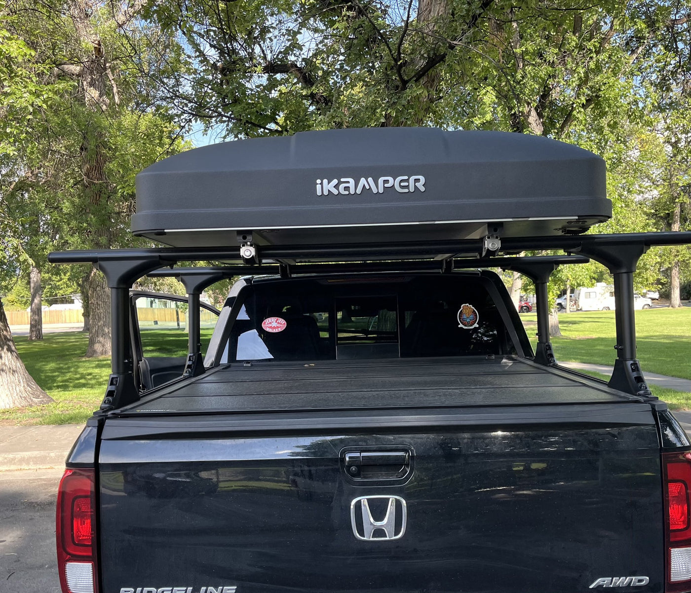 Skycamp 3.0 Mini closed on the truck rack, low-profile Rocky Black hardshell with the iKamper logo across the rear panel — photo 4