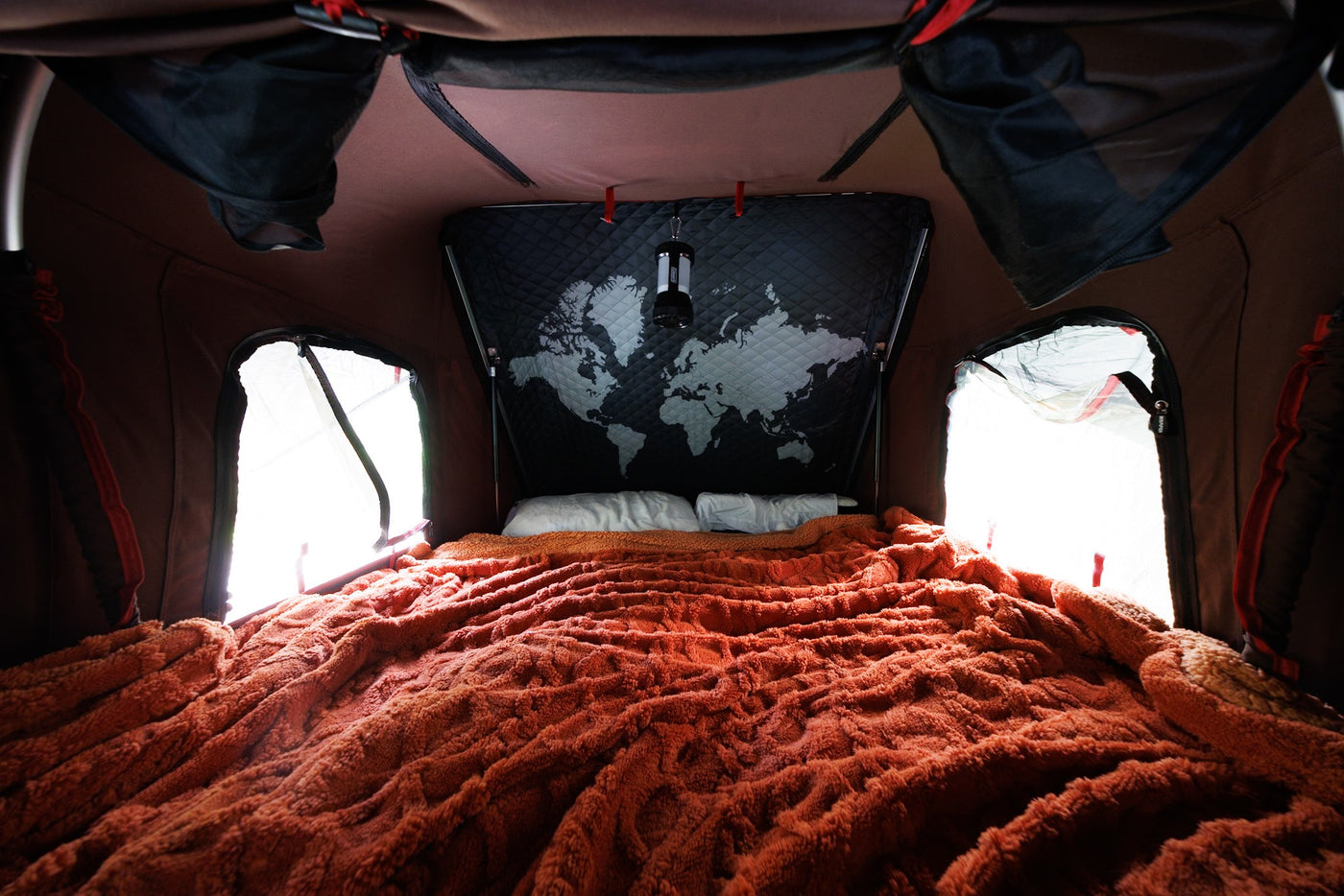  ready for adventures in nature with an SUV.|Comfortable sleeping area within an RV rental tent. Features a soft orange blanket