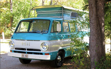 A vintage turquoise and white Dodge pop-top camper van