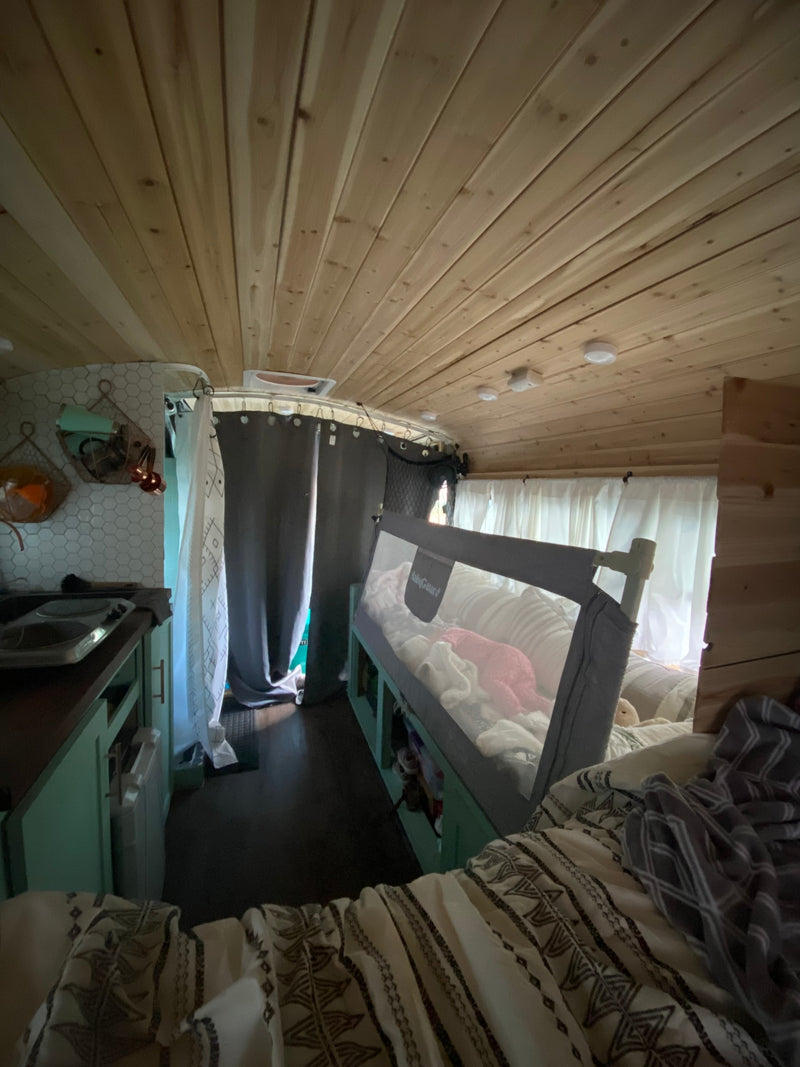  parked lakeside among pines. Ready for adventure!|Mint green skoolie RV rental — photo 14