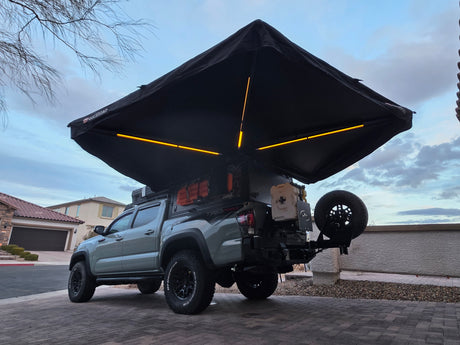 Overlanding Toyota Tacoma TRD Pro with a deployed awning, perfect for camping adventures. Explore with this unique rv rental setup!