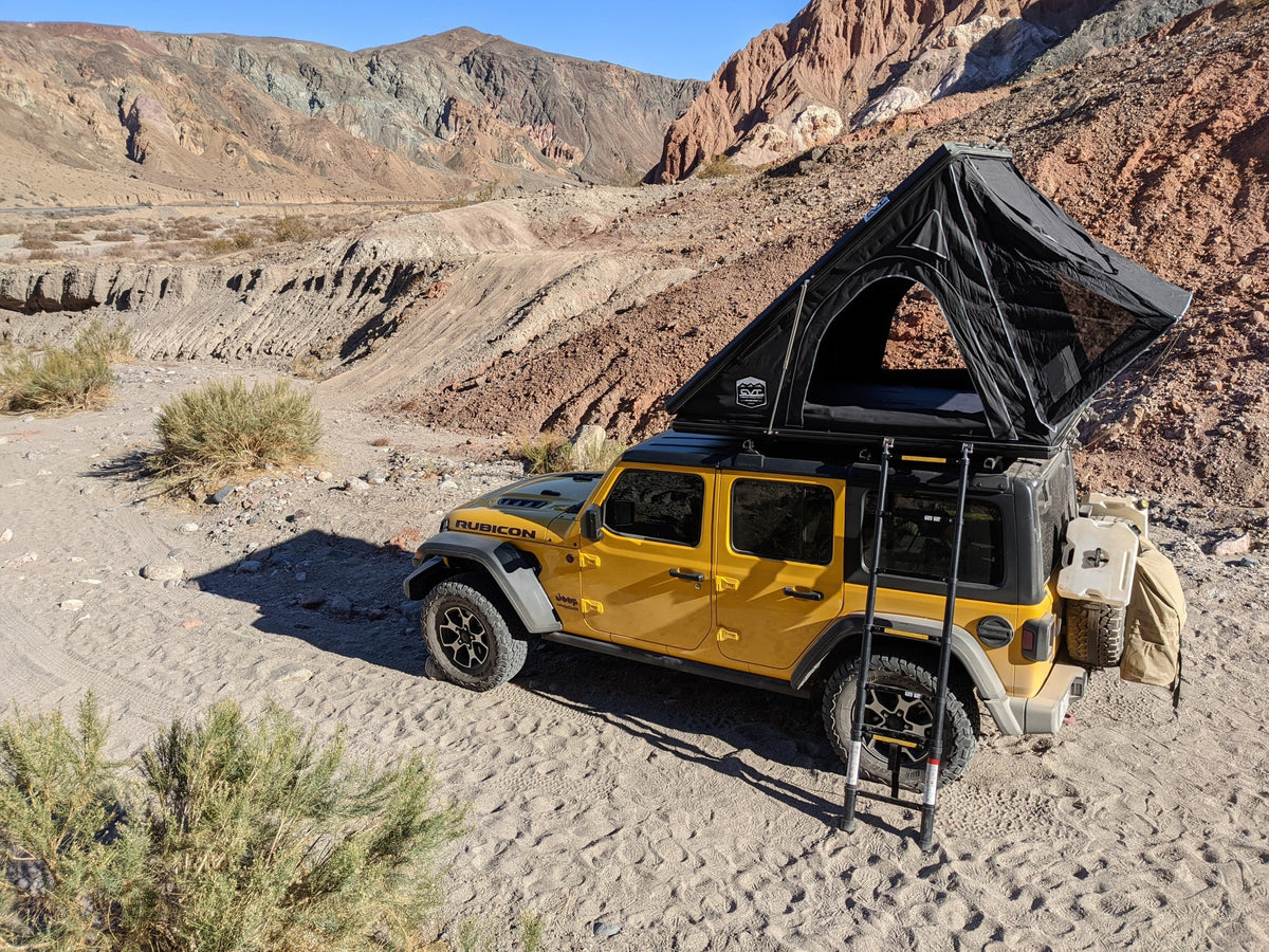 ready for a rugged desert rv rental adventure. Ideal for off-grid camping.|Night camping with an RV rental: a Jeep with a rooftop tent overlooks city lights under a starry sky with the moon & a contrail.|Bright yellow Jeep Rubicon on a rugged canyon trail. Ideal for off-road exploration; ask about RV rental options too!|Yellow Jeep Rubicon at Mojave National Preserve entrance — photo 9