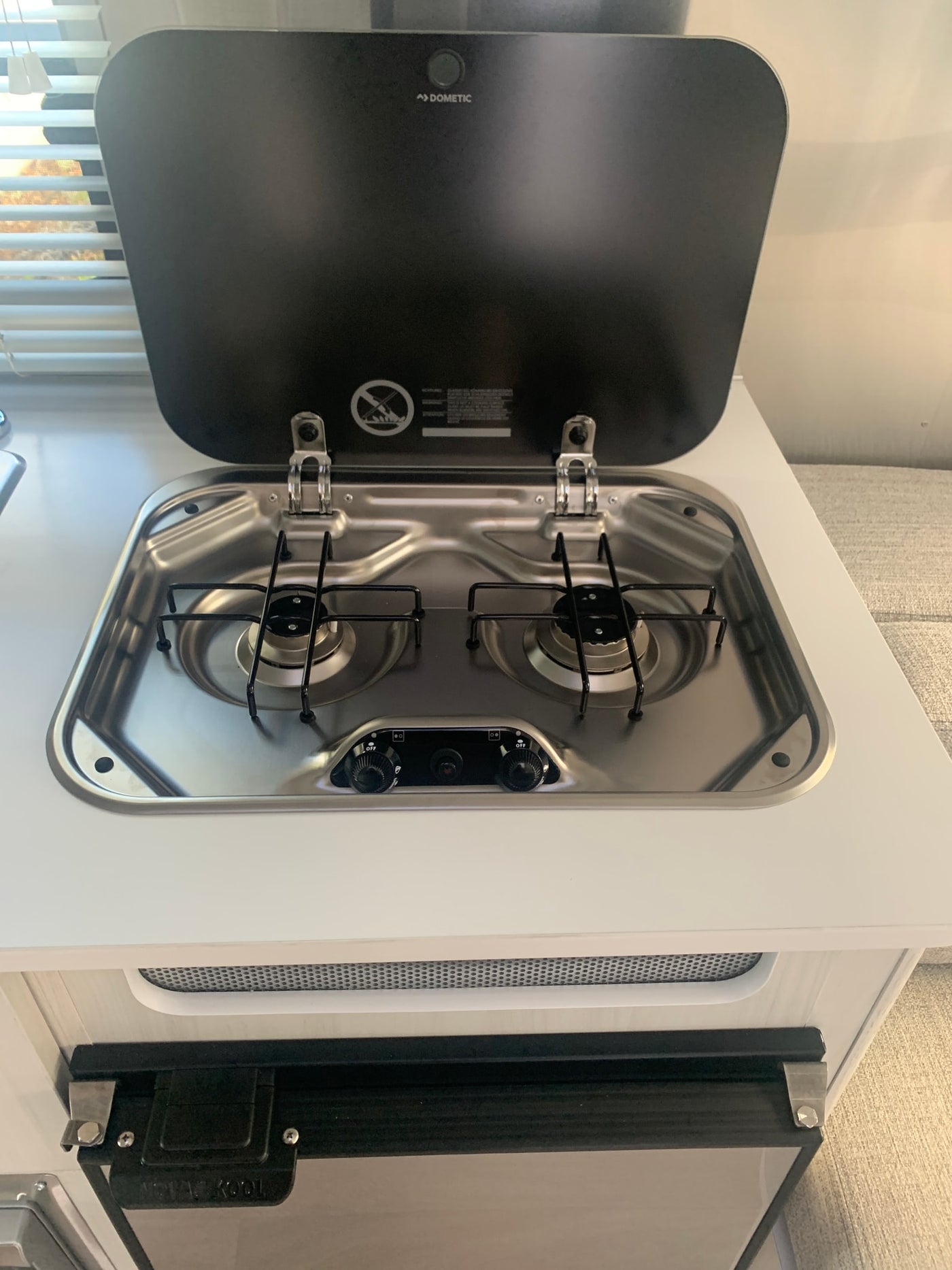 Dometic 2-burner stove, a key feature in this RV rental kitchen, with stainless steel cooktop and controls. — photo 10