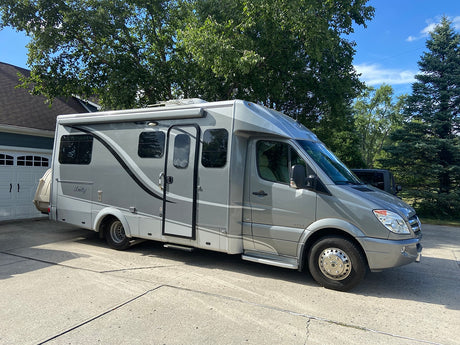 Grey Unity camper van parked on a driveway, ready for your next rv rental adventure.
