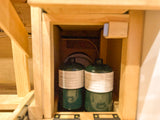 RV rental feature: Two green propane tanks stored in a custom compartment for cooking and heating.